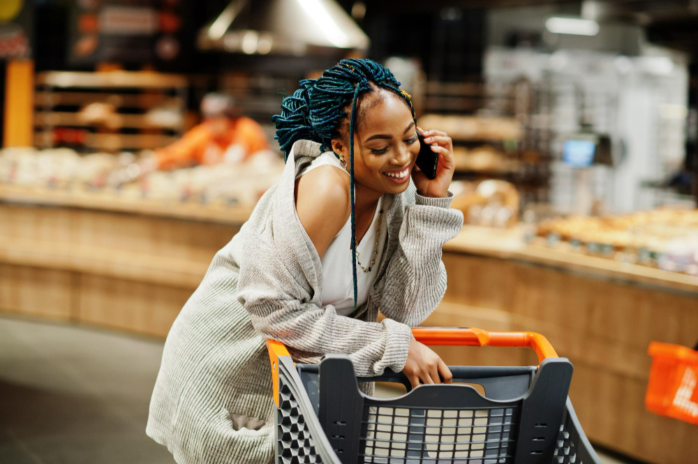 african-american-woman-with-shopping-cart-trolley-supermarket-store-speak-mobile-phone
